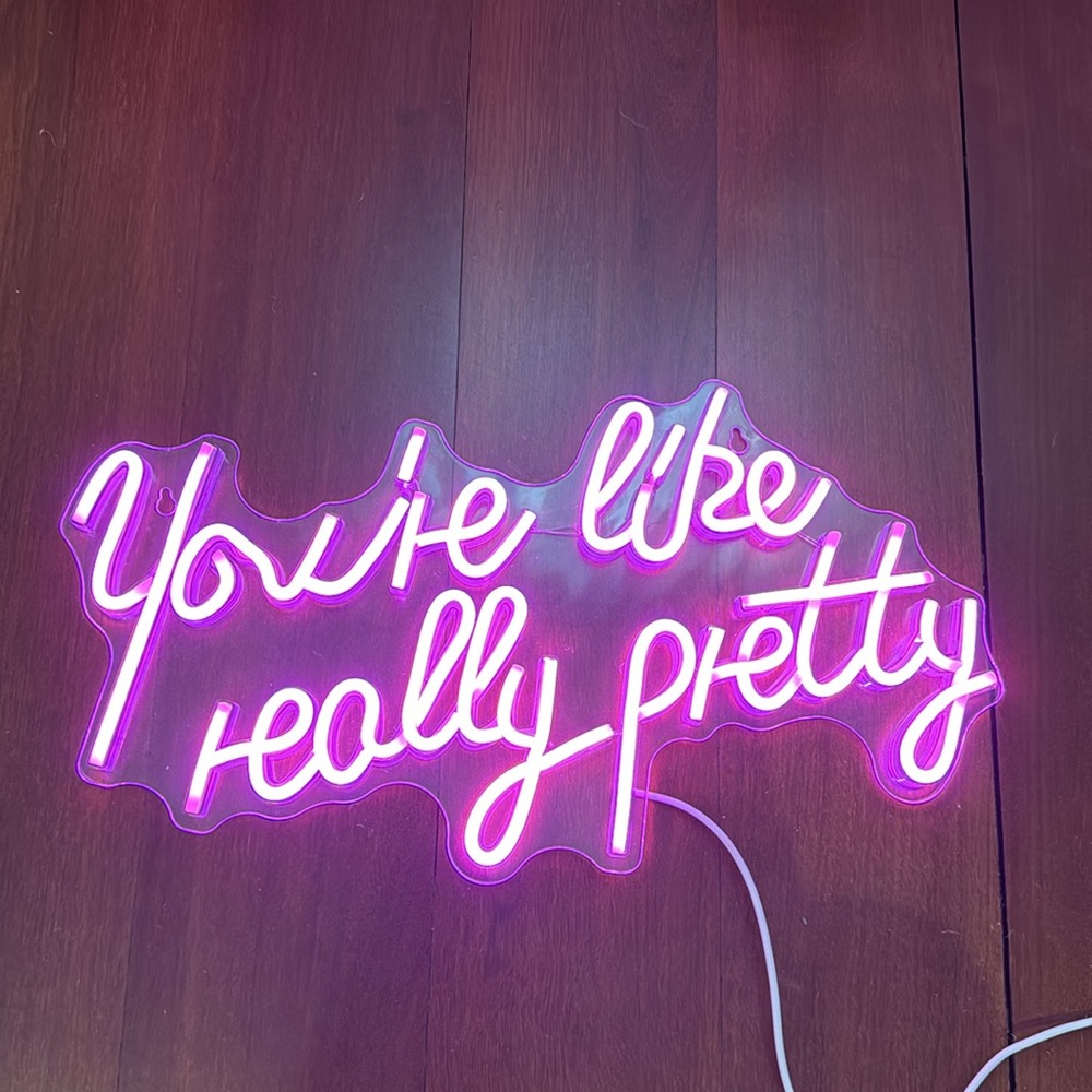 Neon pink sign “You’re like really pretty”